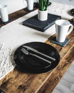 FarnworthComfortable Home In Bolton的木桌上用刀叉的黑色板子