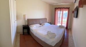 维拉摩拉Vilamoura Marina Lake的一间卧室配有一张带白色床单的床和一扇窗户。