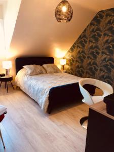 勒芒Au pied du circuit des 24h, chez Céline的卧室配有1张床、1张桌子和1把椅子