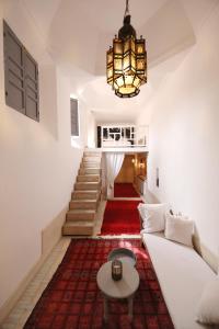 马拉喀什Riad Les Hirondelles Boutique Hotel的客厅配有白色沙发和吊灯。