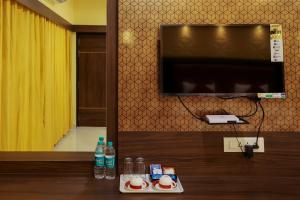 库姆巴科纳姆sri balaji grand hotel的一间配有电视和一张带饮料的桌子的房间