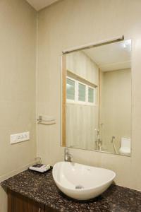 库姆巴科纳姆sri balaji grand hotel的一间带水槽和大镜子的浴室
