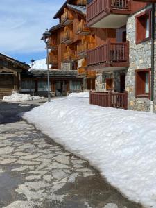 蒂涅Tignes-8-10 personnes-4 chambres-parking的建筑物前的一堆积雪