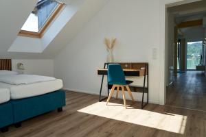 玛丽亚韦尔特Appartements am See的一间卧室配有一张桌子和一张蓝色椅子