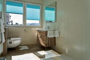 玛丽亚韦尔特Appartements am See的一间带水槽和卫生间的浴室以及窗户。