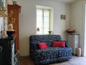 瓦朗赛VILLA ESPERANZA Suite de 2 à 4 personnes proche Zoo de Beauval et châteaux de La Loire的客厅配有带两个红色枕头的黑色沙发