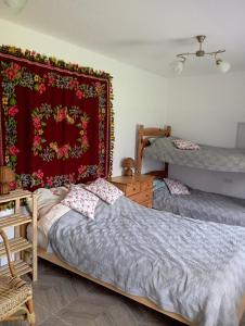 Wólka NadbużnaSołtysówka的一间卧室配有两张床和红色毯子