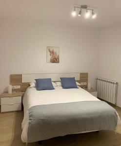 贝尔维尔德赛当亚CAL JAN - La Muralla的一间卧室配有一张大床和两个蓝色枕头