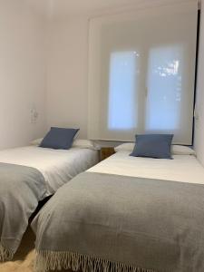 贝尔维尔德赛当亚CAL JAN - La Muralla的两张睡床彼此相邻,位于一个房间里