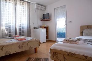 安吉Villa Horizon Canj的客房设有两张床、一个窗户和一台冰箱。