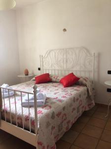 斯佩洛Il giardino delle rose的卧室配有带红色枕头的白色床
