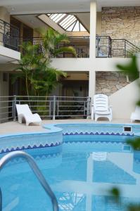 埃利萨镇Hotel Suite & Spa Verdesolaro的一座带椅子的大型游泳池和一座建筑