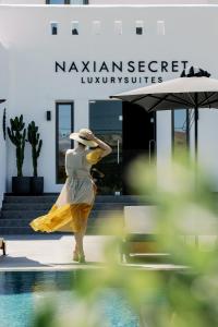 纳克索乔拉Naxian Secret的身着黄色衣服的女人站在游泳池旁边