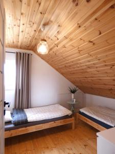 斯莫尔德兹斯基拉斯Domki Trzy - 3的配有木天花板的客房内的两张床