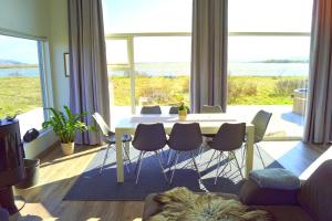 劳加尔瓦特恩Austurey - Lakefront Villa的客厅配有桌椅和大窗户
