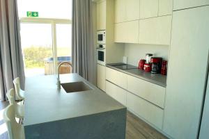 劳加尔瓦特恩Austurey - Lakefront Villa的厨房配有白色橱柜和台面