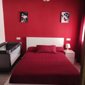 本迪亚Apartamento Buendia的红色的卧室,配有一张红色墙壁的床
