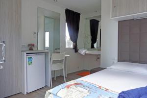 La CinquantinaAgricampeggio Ippocampo的一间卧室配有一张床铺和一张桌子,还设有一间厨房