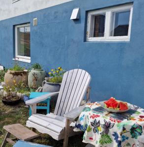 贝勒沃格Liten leilighet i Berlevåg的蓝色的房子,配有桌子和白色椅子