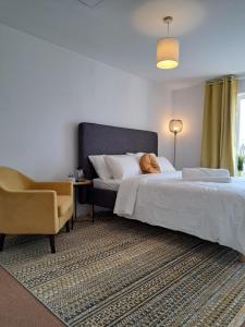 格雷斯瑟罗克Luxury Rooms In Furnished Guests-Only House Free WiFi West Thurrock的一间卧室配有一张床和一把椅子