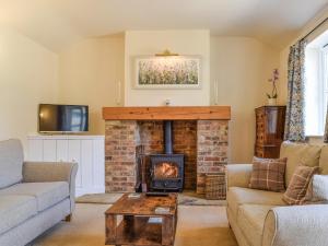 AdstockWayside Cottage的客厅设有壁炉和电视。