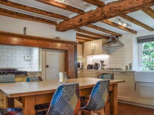 AdstockWayside Cottage的厨房配有木桌和椅子