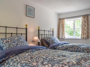 AdstockWayside Cottage的卧室设有两张床,带窗户