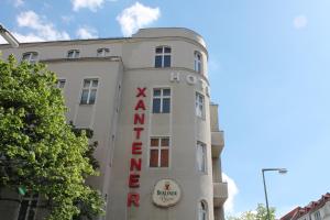 柏林艾克桑特膳食酒店的白色的建筑,旁边标有标志