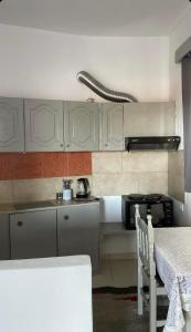 克兰尼蒂Tasos_Studios&Apartments 2的厨房配有白色橱柜、桌子和炉灶。