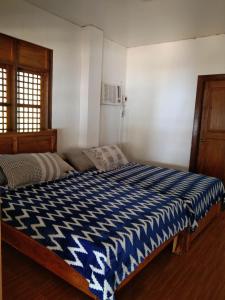 Ohana Resort的一间卧室配有一张带蓝色和白色棉被的床