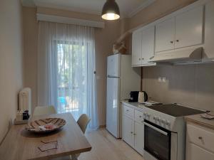 卡利斯托斯Eva's apartment的厨房配有桌子和白色冰箱。