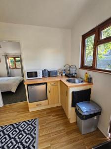 坎伯恩Picturesque Cabin in Cornwall的一个带水槽的厨房和客房内的电视