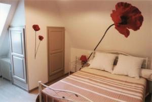Appart'Aubrac的卧室配有一张挂着红花的床。