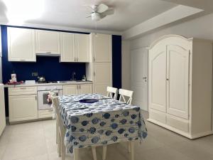 圣温琴佐Casa Morandi MARE的厨房配有桌子、白色橱柜和蓝色的墙壁