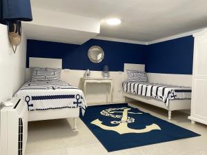圣温琴佐Casa Morandi MARE的一间卧室设有两张床和蓝色的墙壁