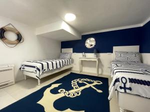 圣温琴佐Casa Morandi MARE的一间卧室配有两张床,铺有锚地地毯