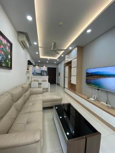 胡志明市Căn hộ ngắn hạn Thành phố Hồ Chí Minh Gần sân bay的客厅设有大沙发和电视