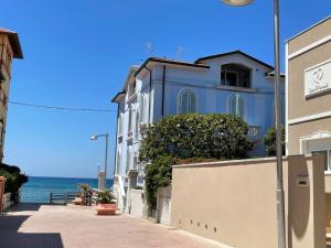 圣温琴佐Casa Morandi MARE的海边街道上的蓝色建筑