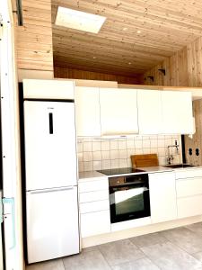 瓦尔贝里Neptuni Bed and Kitchen的厨房配有白色橱柜和冰箱。