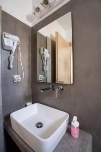 米克诺斯城利亚纳公寓的浴室设有白色水槽和镜子