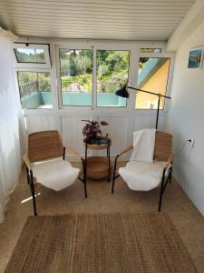 普拉泽里什Casa Vida Alegre的带窗户的客房内配有两把椅子和一张桌子
