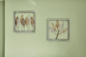 拉里萨Το πιο ευχάριστο διαμέρισμα της πόλης的墙上有两张叶子的画框