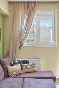 拉里萨Το πιο ευχάριστο διαμέρισμα της πόλης的窗前的紫色沙发