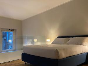 佛罗伦萨Chic Stay Boutique Apartments的一间卧室配有一张带两盏灯的床和一扇窗户。