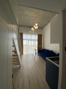 弗罗茨瓦夫Apartament Wrocław-Lotnisko的厨房以及带蓝色沙发的起居室。