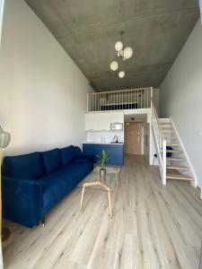 弗罗茨瓦夫Apartament Wrocław-Lotnisko的客厅设有蓝色的沙发和楼梯。
