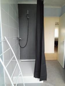 CréhangeEden的浴室内配有黑色淋浴帘和淋浴