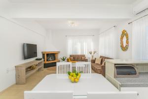 玛利亚Maela Luxury Suite的白色的客厅配有桌子和沙发