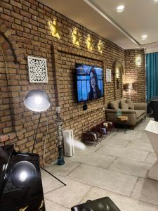 苏莱曼尼亚Khan Saray的客厅设有砖墙和平面电视