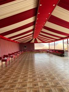 瓦迪拉姆Al Rifi Luxury Camp的大房间设有红色和白色的天花板和椅子